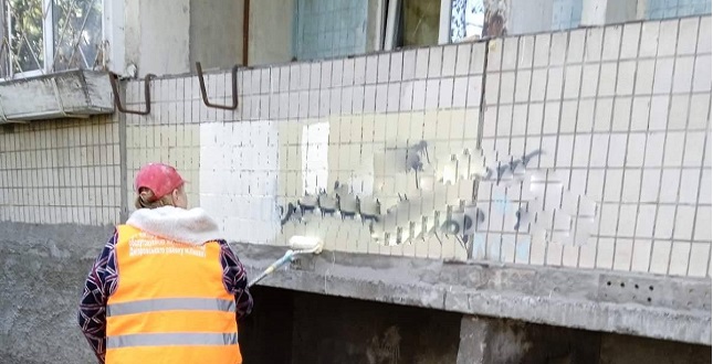 Комунальники зафарбовують написи на фасадах будинків